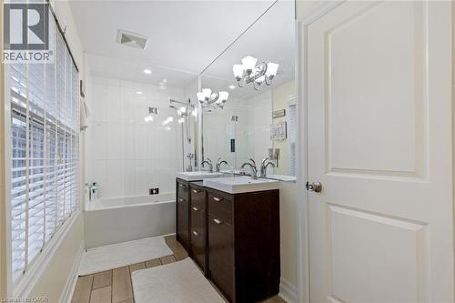 Bathroom with vanity, tiled shower / bath combo, and a notable chandelier - 1073 North Service Road, Hamilton, ON - Indoor Photo Showing Bathroom