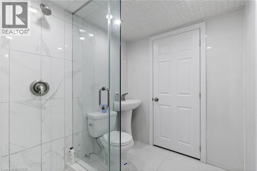 Bathroom featuring tile patterned floors, a shower with shower door, and toilet - 1073 North Service Road, Hamilton, ON - Indoor Photo Showing Bathroom