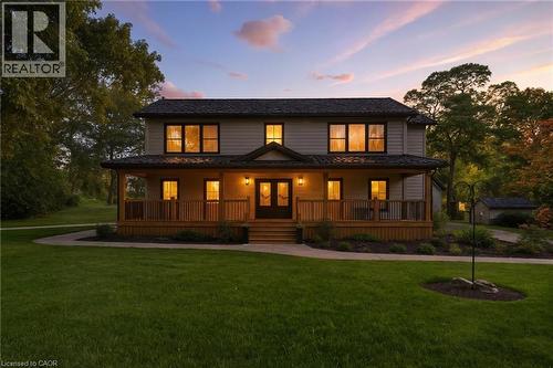 View of front facade with covered porch, a front yard, and french doors - 115 Lakeshore Road, Port Burwell, ON - Outdoor With Deck Patio Veranda With Facade