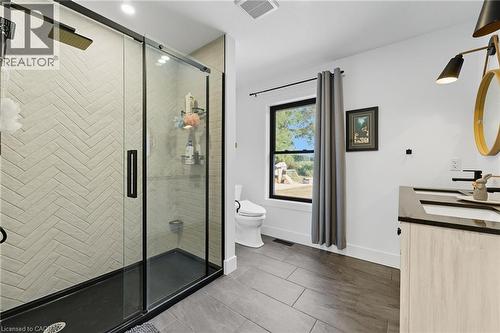 Full bathroom featuring a stall shower, double vanity, and dark tile patterned flooring - 115 Lakeshore Road, Port Burwell, ON - Indoor Photo Showing Bathroom