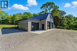 Detached garage featuring view of wooded area - 