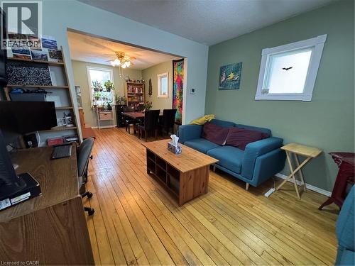 comfortable living room, warmed by a red gas stove and ceiling fan - 344 Paisley Road, Guelph, ON - Indoor Photo Showing Living Room