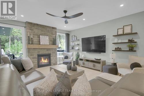 Upgraded floor to ceiling stone fireplace in lvgrm - 295 Ridgemont Drive, Beckwith, ON - Indoor Photo Showing Living Room With Fireplace