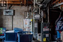 Utility room featuring water heater, electric panel, heating unit, and laundry. - 