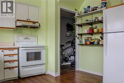 Kitchen featuring white appliances, light countertops, dark wood-style flooring, and dual tone cabinets - 