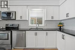 Upgraded kitchen with granite counterops, new cupboard doors, and backsplash - 