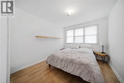 Bedroom featuring wood finished floors and baseboards - 