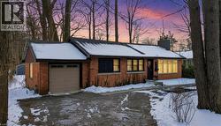 Ranch-style house with a chimney, brick siding, and a garage - 