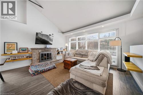Living room with a stone fireplace, dark wood finished floors, high vaulted ceiling, and recessed lighting - 276 Lakeshore Road W, Oakville, ON - Indoor Photo Showing Living Room With Fireplace