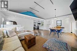 Living room with recessed lighting, wood finished floors, and lofted ceiling - 