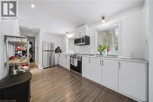 Kitchen featuring white cabinetry, stainless steel appliances, light countertops, and dark wood finished floors - 276 Lakeshore Road W, Oakville, ON - Indoor Photo Showing Kitchen With Upgraded Kitchen