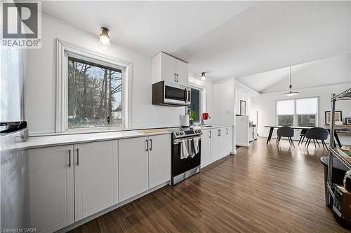 Kitchen with white cabinets, vaulted ceiling, light countertops, dark wood finished floors, and appliances with stainless steel finishes - 276 Lakeshore Road W, Oakville, ON - Indoor Photo Showing Kitchen