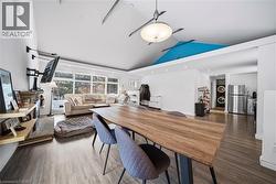 Dining area with stacked washer / drying machine, wood finished floors, recessed lighting, and high vaulted ceiling - 
