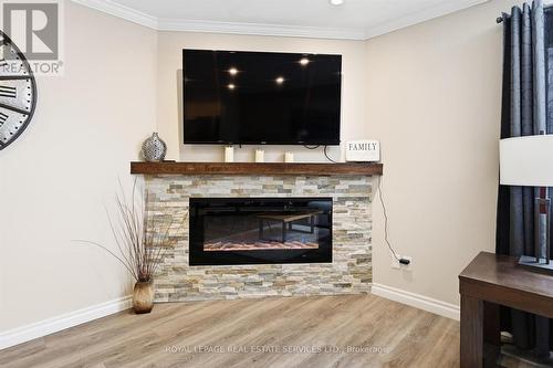 Living Room Features a Corner Electric Fireplace - 51 - 26 Moss Boulevard, Hamilton, ON - Indoor Photo Showing Living Room With Fireplace