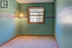 Upper North-West Bedroom 3: Another tranquil space with carpeted floors and classic wood trim, offering a restful retreat for the night. - 