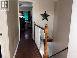 Hall with dark wood-type flooring and an upstairs landing - 