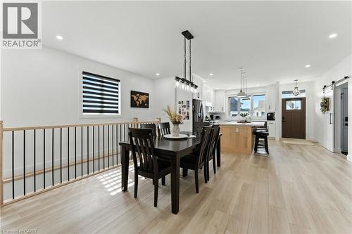 Dining space featuring a barn door, light wood-style flooring, and recessed lighting - 9 Macneil Court, Port Burwell, ON - Indoor Photo Showing Dining Room