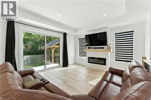 Living area with a large fireplace, recessed lighting, light wood-style floors, and a raised ceiling - 9 Macneil Court, Port Burwell, ON - Indoor Photo Showing Living Room With Fireplace