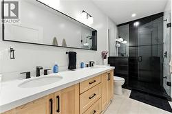 Full bath with double vanity, a stall shower, recessed lighting, and light tile patterned floors - 