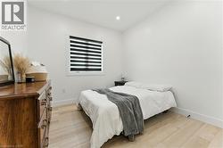 Bedroom with light wood finished floors and recessed lighting - 
