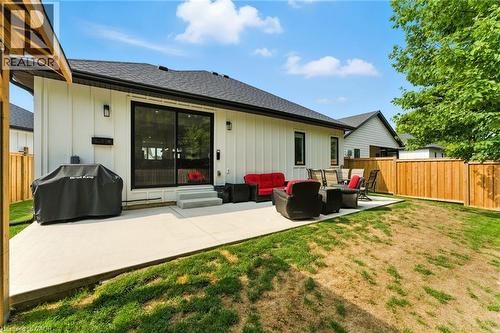 Back of property featuring outdoor lounge area, a patio, a shingled roof, and board and batten siding - 9 Macneil Court, Port Burwell, ON - Outdoor With Deck Patio Veranda