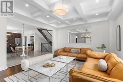 Great room with coffered ceiling and pot lighting. - 