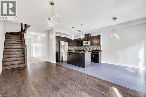 Kitchen with a breakfast bar area, open floor plan, pendant lighting, and stainless steel refrigerator with ice dispenser - 89 Sonoma Valley Crescent, Hamilton, ON - Indoor Photo Showing Kitchen With Upgraded Kitchen