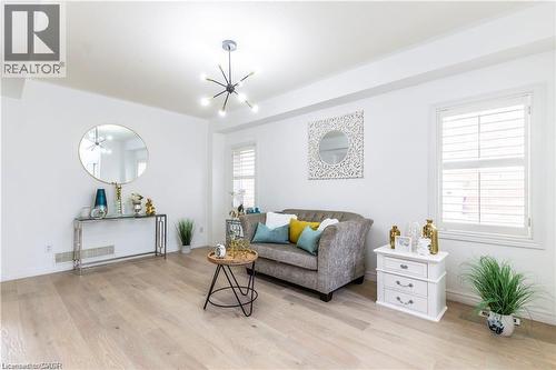 Living area featuring suspended lighting and light wood finished floors - 252 Thorner Drive Unit# Upper, Hamilton, ON - Indoor Photo Showing Living Room