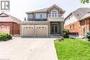 View of front of property featuring french doors, stone siding, an attached garage, concrete driveway, and a balcony - 252 Thorner Drive Unit# Upper, Hamilton, ON  - Outdoor 