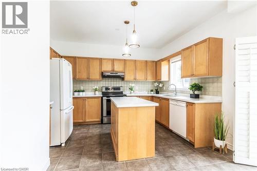 Kitchen featuring light countertops, a kitchen island, white appliances, and pendant lighting - 252 Thorner Drive Unit# Upper, Hamilton, ON - Indoor Photo Showing Kitchen