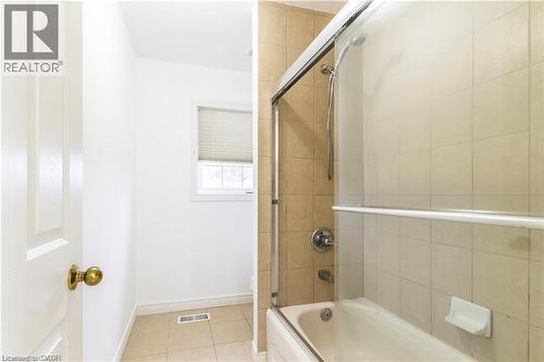 Bathroom with enclosed tub / shower combo and light tile patterned flooring - 252 Thorner Drive Unit# Upper, Hamilton, ON - Indoor Photo Showing Bathroom