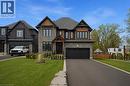 Contemporary dwelling featuring stone and wood-look siding, a dark asphalt shingle roof, and black-framed windows - 7 Bartlett Avenue, Grimsby, ON  - Outdoor With Facade 