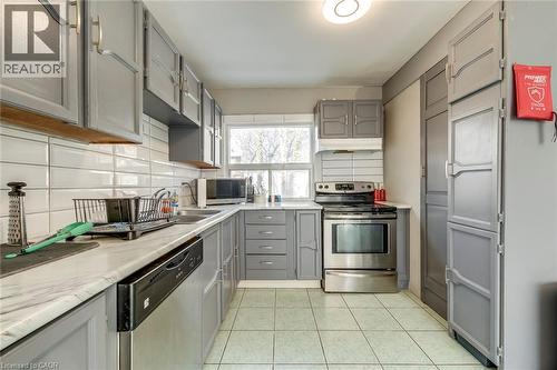 Kitchen featuring gray cabinetry, backsplash, stainless steel appliances, and light countertops - 142 Ewen Road, Hamilton, ON - Indoor Photo Showing Kitchen With Double Sink