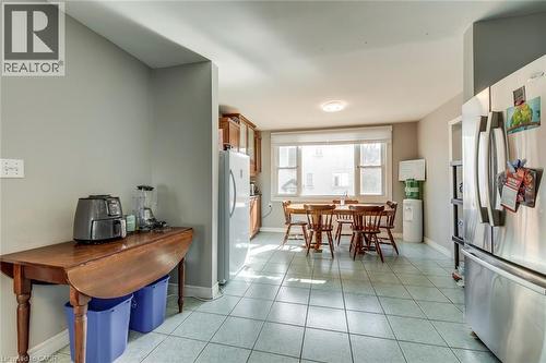 Kitchen with freestanding refrigerator, light tile patterned flooring, and wood finish cabinetry - 142 Ewen Road, Hamilton, ON - Indoor Photo Showing Dining Room
