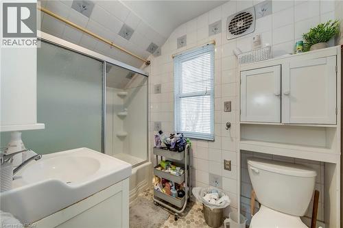 Full bath with vanity, tile walls, shower / bath combination with glass door, and vaulted ceiling - 142 Ewen Road, Hamilton, ON - Indoor Photo Showing Bathroom