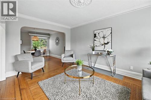 Sitting room featuring arched walkways, hardwood / wood-style flooring, and ornamental molding - 1047 Main Street E, Hamilton, ON - Indoor Photo Showing Living Room