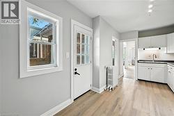 Kitchen featuring dark countertops, white cabinetry, radiator, and plenty of natural light - 
