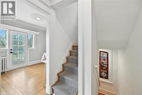 Stairway with ornamental molding, hardwood / wood-style floors, and radiator - 1047 Main Street E, Hamilton, ON - Indoor Photo Showing Other Room