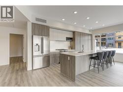 Kitchen with stainless appliances, abundant cabinetry, and large island with quartz counters - 
