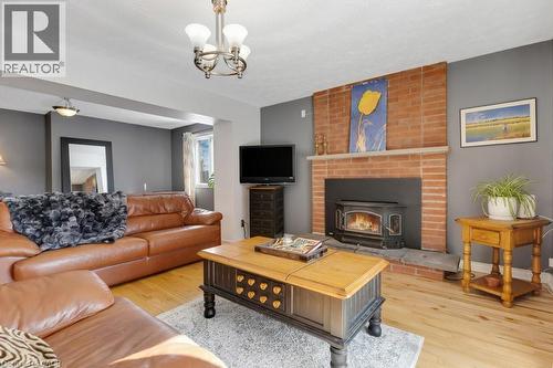 Living room with light wood-type flooring, a chandelier, and a wood stove - 148 Cowan Boulevard, Cambridge, ON - Indoor Photo Showing Living Room With Fireplace