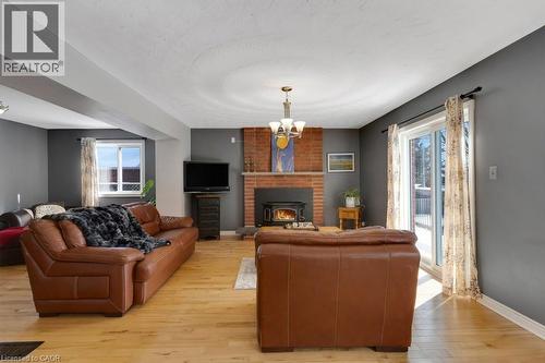 Living room with light wood finished floors and suspended lighting - 148 Cowan Boulevard, Cambridge, ON - Indoor Photo Showing Living Room With Fireplace
