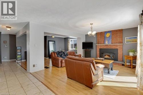 Living area with hanging lights, light wood-style floors, and a wood stove - 148 Cowan Boulevard, Cambridge, ON - Indoor Photo Showing Living Room With Fireplace