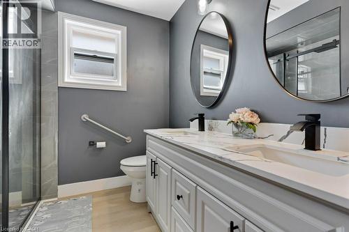 Full bath featuring double vanity, a stall shower, and light wood-type flooring - 148 Cowan Boulevard, Cambridge, ON - Indoor Photo Showing Bathroom