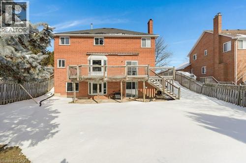 Snow covered property with brick siding, a patio area, a fenced backyard, a chimney, and a wooden deck - 148 Cowan Boulevard, Cambridge, ON - Outdoor