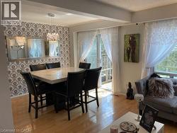 Dining space with light wood-style floors, baseboards, a chandelier, and a textured ceiling - 