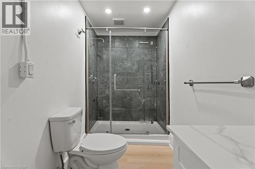 Full bath featuring a stall shower, light wood-type flooring, and recessed lighting - 93 John Street S, Hamilton, ON 