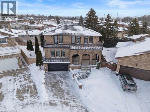 View of front of home featuring a garage, a balcony, brick siding, a residential view, and driveway - 16 Bosna Court, Hamilton, ON - Outdoor