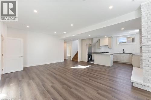 Unfurnished living room with dark wood-style floors and recessed lighting - 16 Bosna Court, Hamilton, ON - Indoor Photo Showing Kitchen