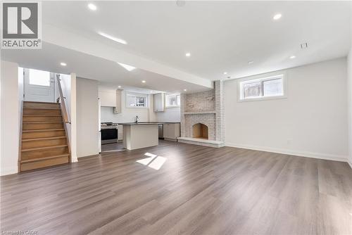 Unfurnished living room with healthy amount of natural light, a brick fireplace, dark wood finished floors, and recessed lighting - 16 Bosna Court, Hamilton, ON - Indoor With Fireplace