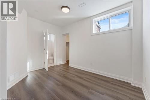 Unfurnished bedroom with dark wood-style floors, ensuite bathroom, and a spacious closet - 16 Bosna Court, Hamilton, ON - Indoor Photo Showing Other Room